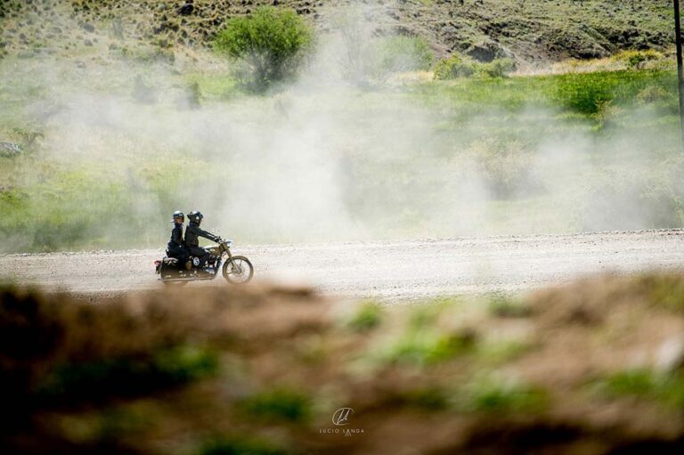 Pilote et passagère sur une Royal Enfield dans la poussière d'une piste de Patagonie