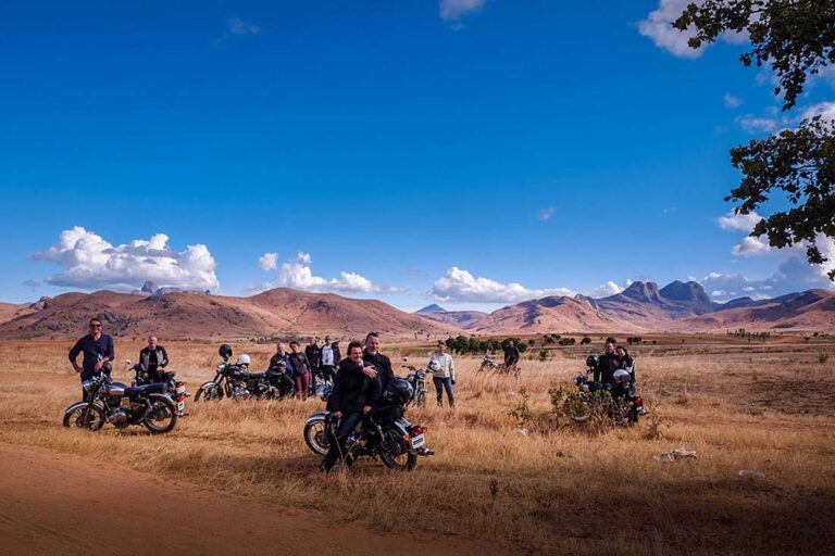 Groupe de voyageurs et leurs motos dans les hauts plateaux de Madagascar après la réservation de leur voyage moto
