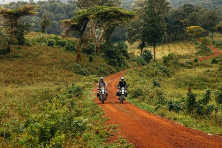 Deux motards sur une piste de latérite rouge en Tanzanie, un road trip moto accessible avec un niveau de pilotage intermédiaire